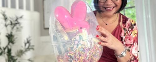 Woman holding a Way to Celebrate Jumbo Plastic Egg filled with Easter gifts and treats