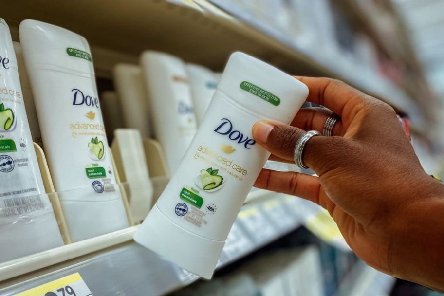 a womans hand holding a deodorant stick