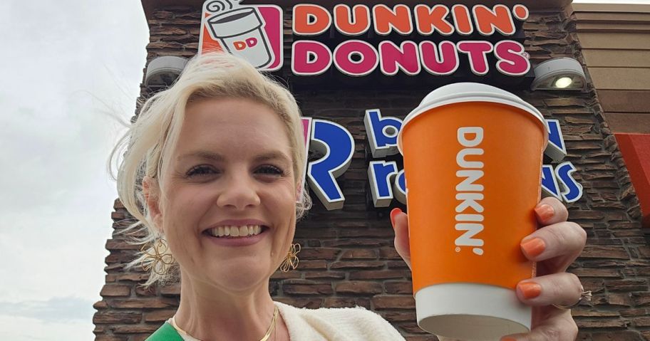 stefanie standing in front of dunkin' sign holding drink
