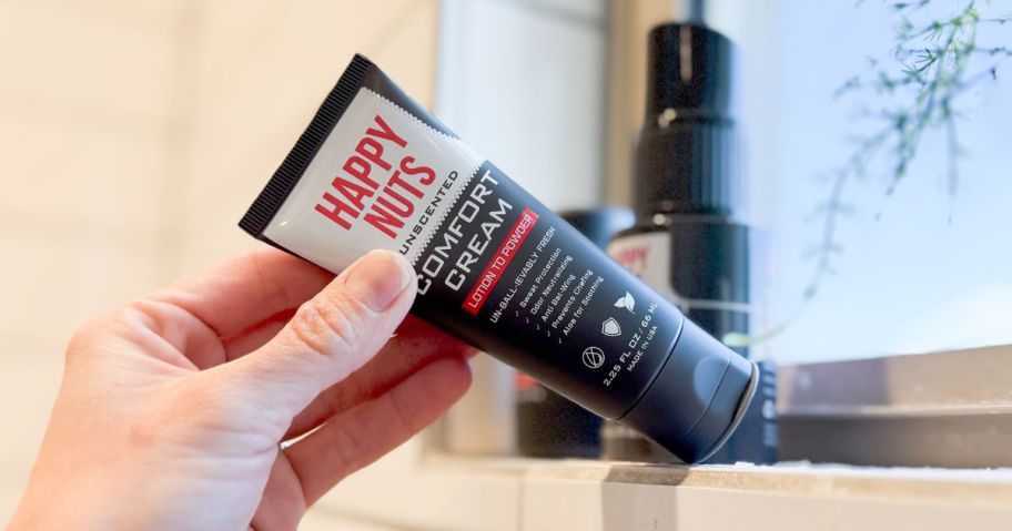 hand holding happy nuts comfort cream in bathroom