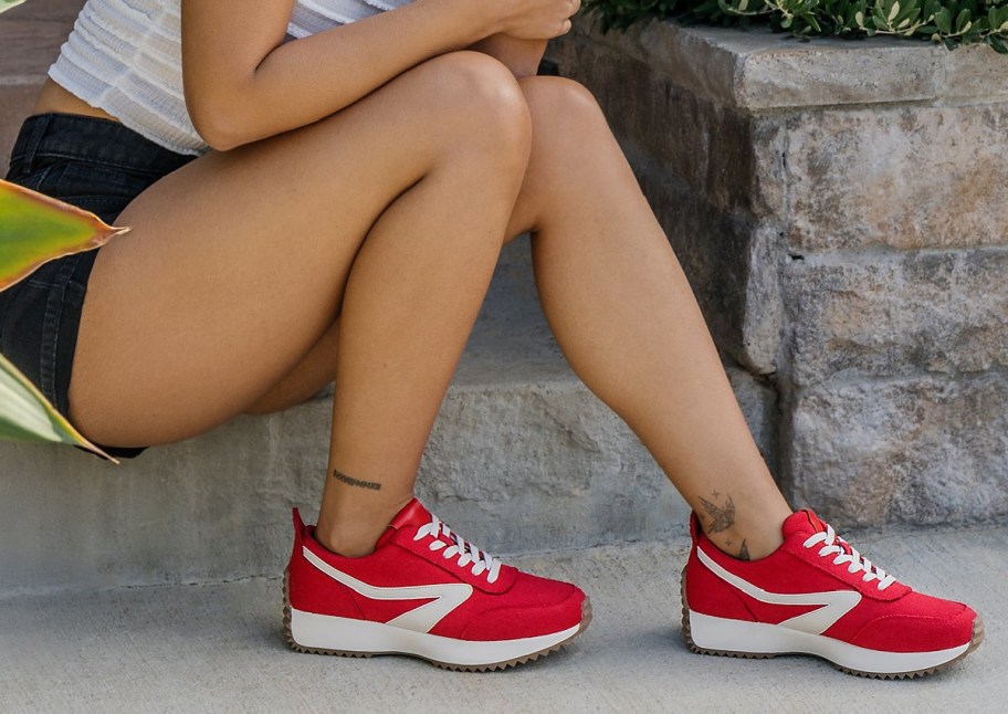 woman wearing red jogger sneakers