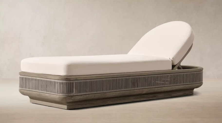 stock photo of woven chaise lounge with an arch shaped pillow