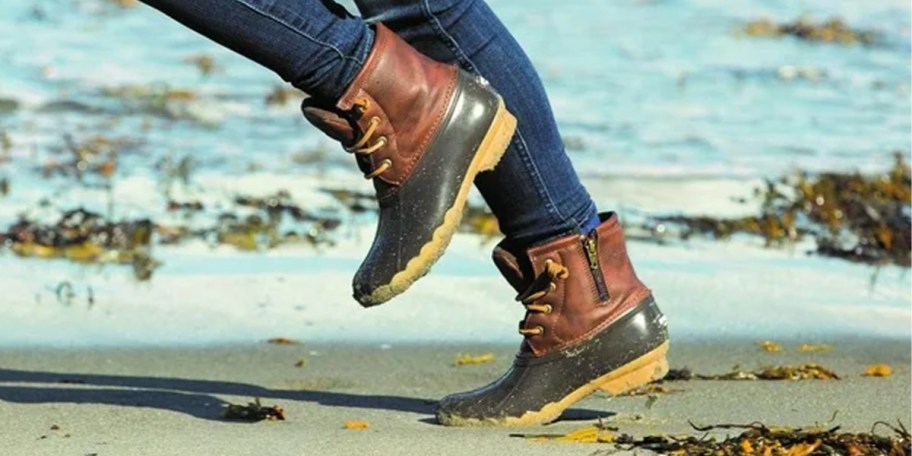 kid wearing brown and black boots near water