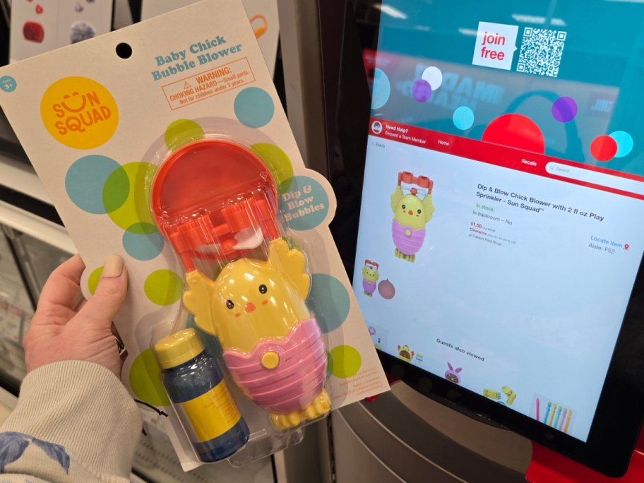A hand holds a "Sun Squad Baby Chick Bubble Blower" package, featuring a yellow chick toy and bubble solution. A store screen displays the same product.