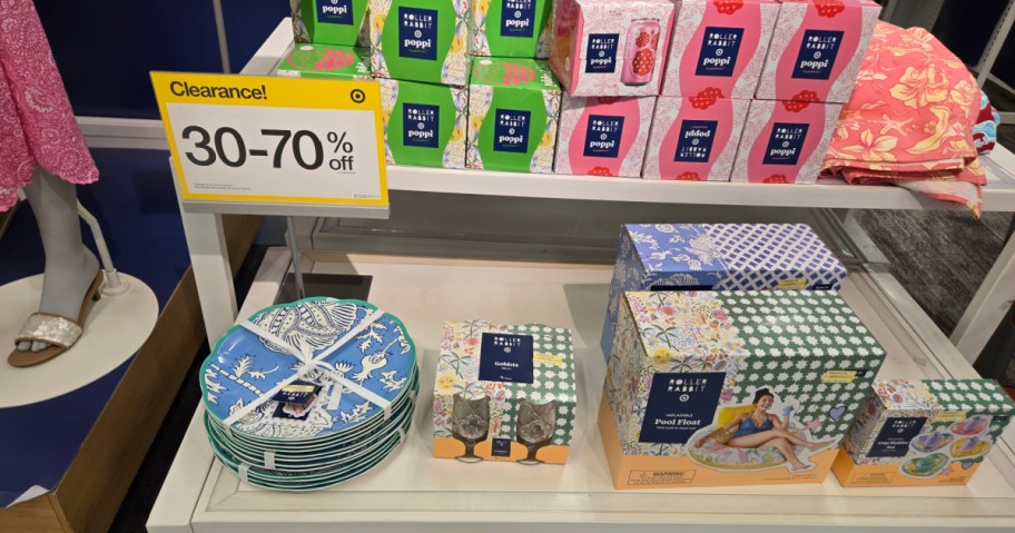 Clearance sale display featuring colorful printed boxes and decorative plates. A sign indicates discounts of 30-70% off.