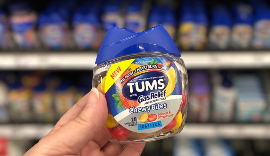 womans hand holding a bottle of tums chews