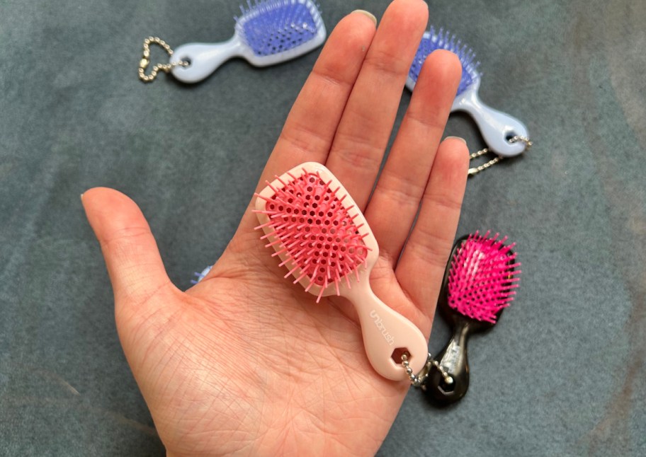 pink mini brush keychain in palm of hand