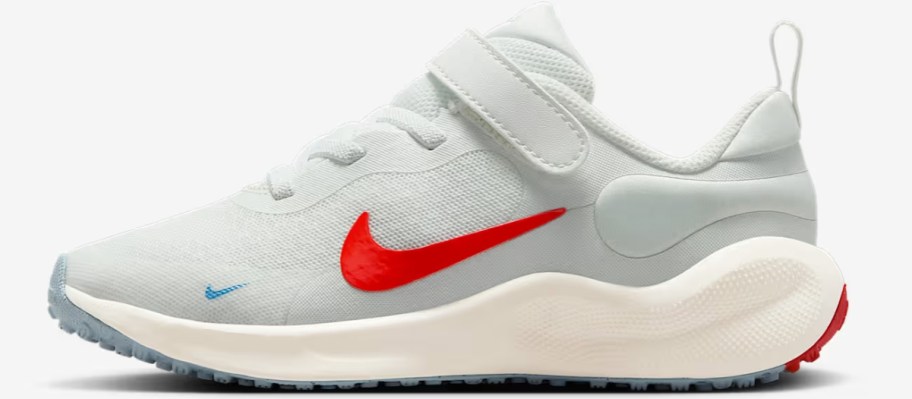 a grey, red, and white kids Nike running shoe