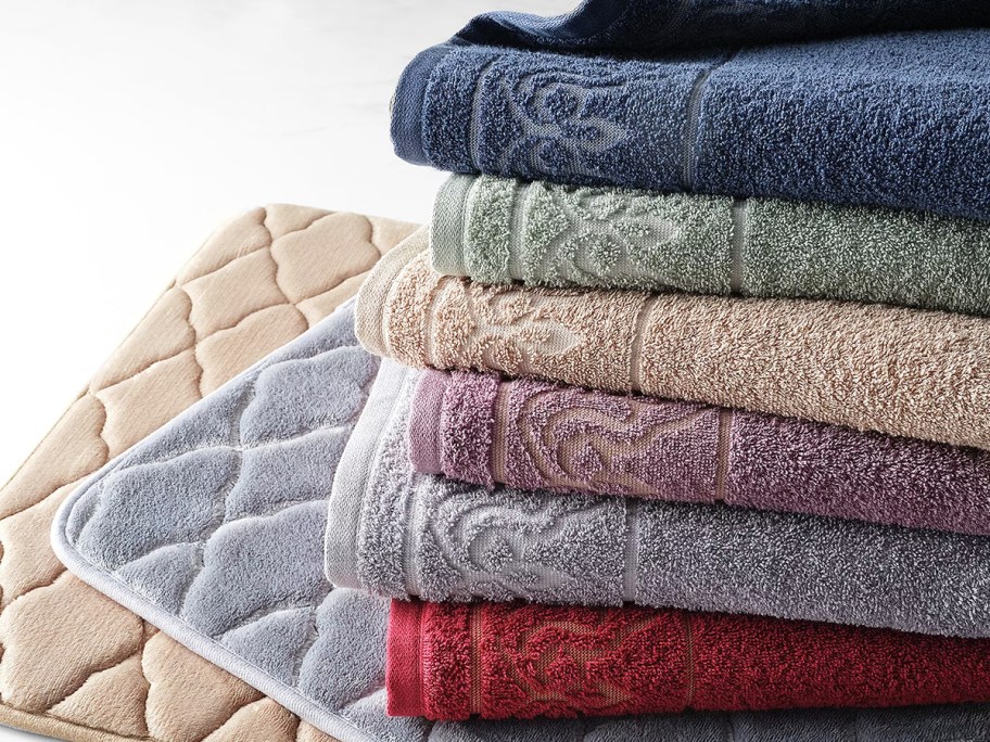 stack of bath towels on top of bath rugs