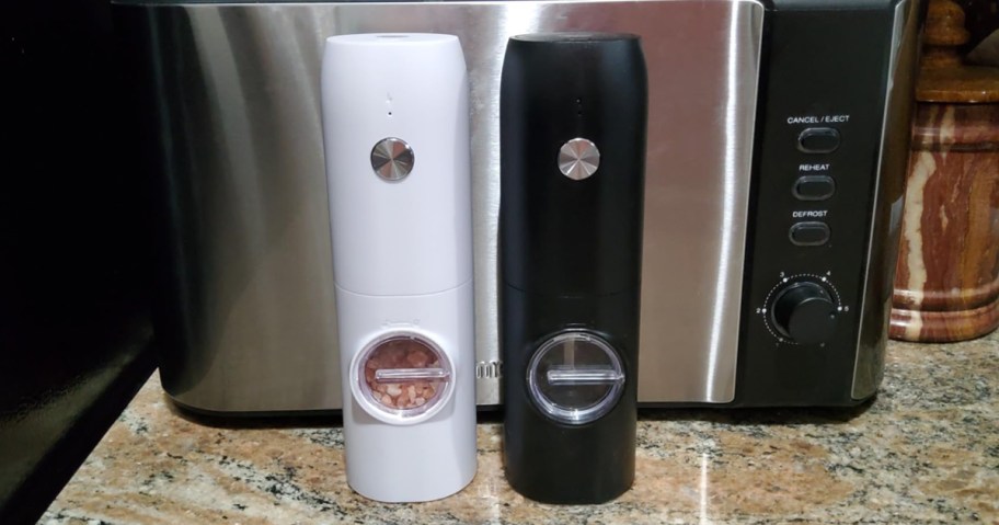 salt and pepper grinders on counter in front of a stainless steel toaster