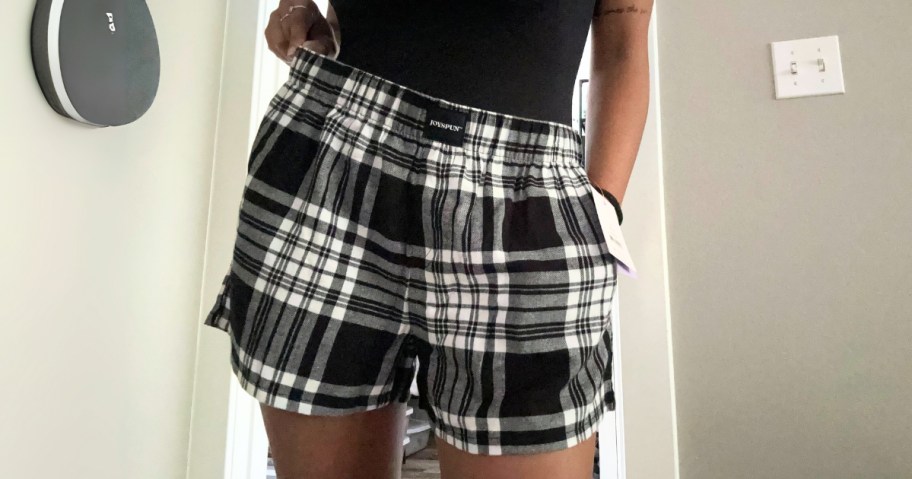 woman wearing black and white plaid boxer pajama shorts