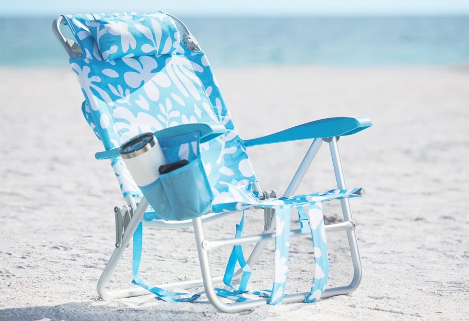 blue and white floral print beach chair in sand