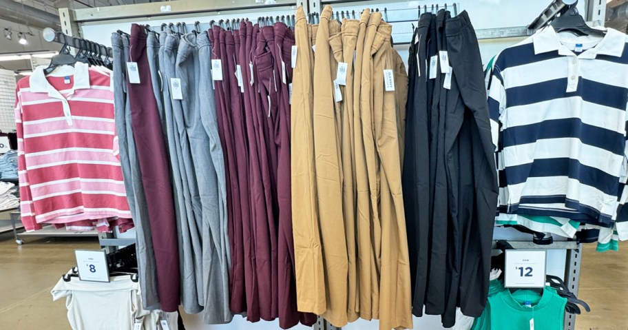 various colors of pants hanging on display in store