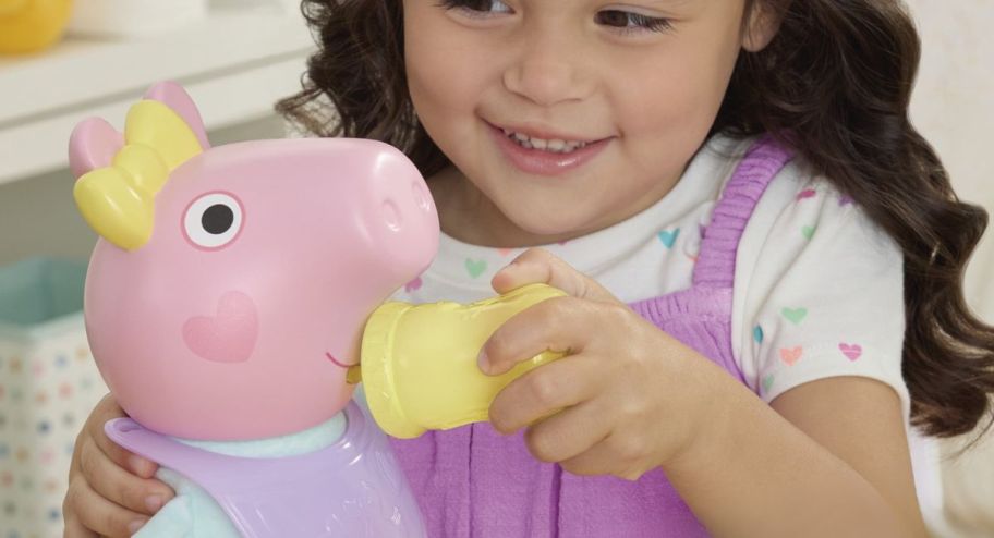 Girl feeding new peppa pig baby doll