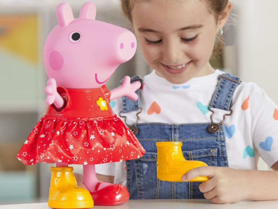 little girl playing with Peppa pig dancing doll