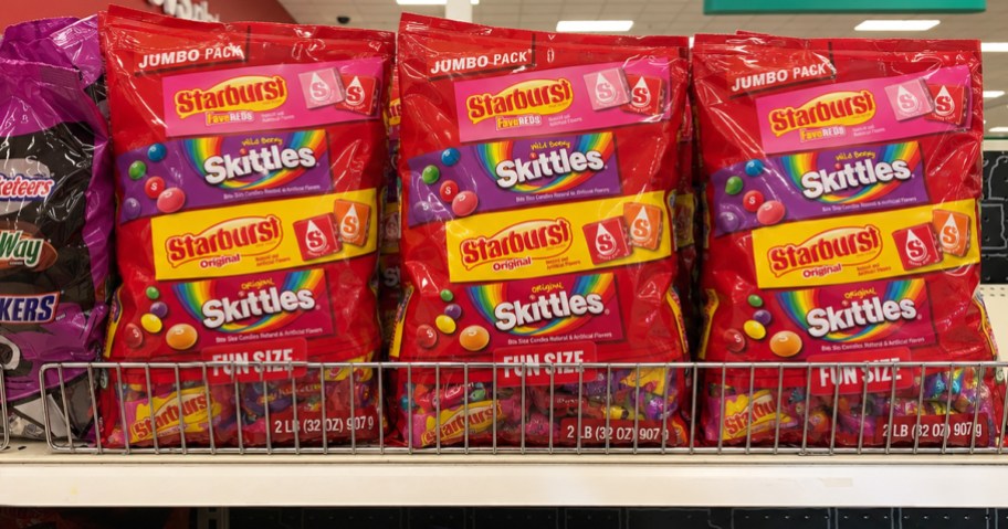 red bags of Skittles & Starburst candies on a store shelf