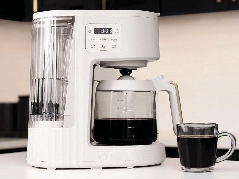 white coffee maker on counter with mug of coffee