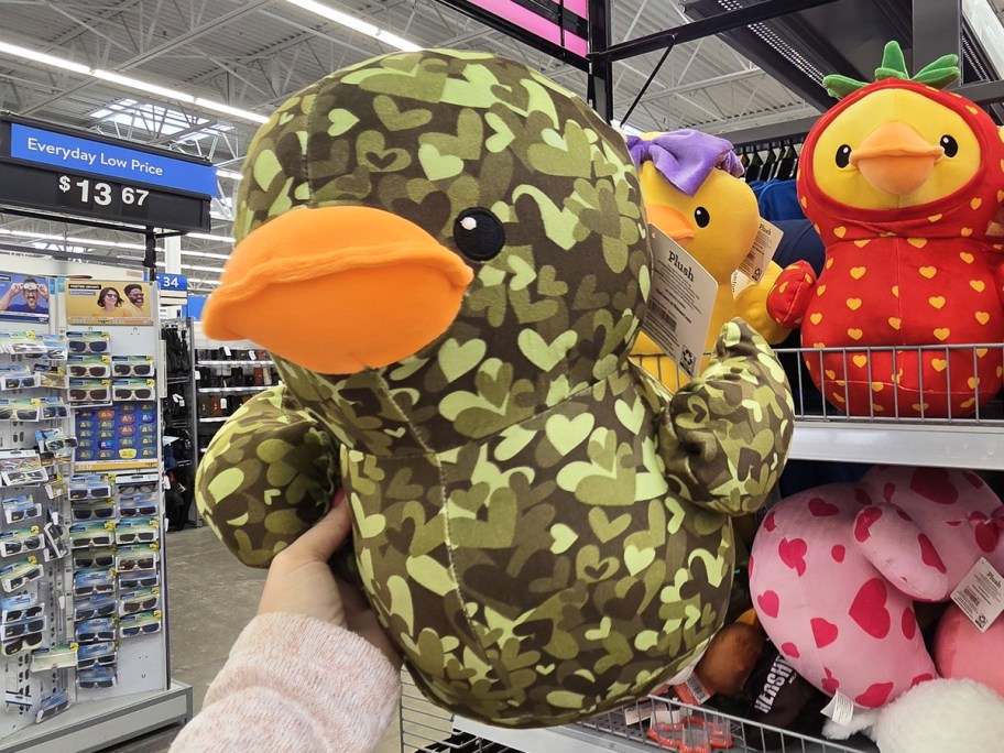 hand holding up a camo print duck plush in store