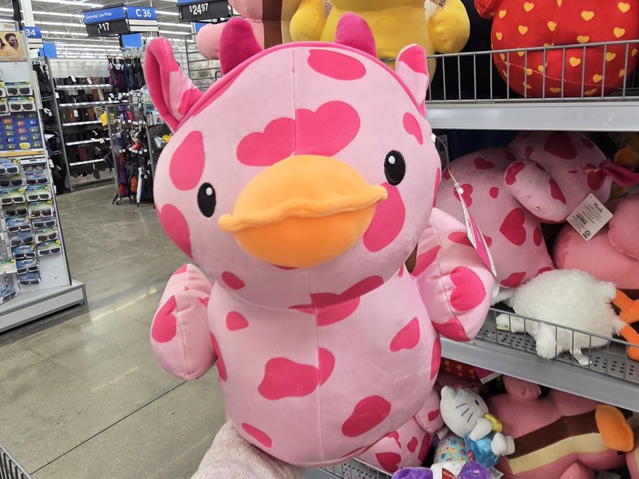 hand holding a pink cow print duck plush