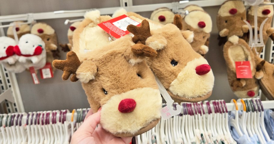 hand holding up a pair of reindeer slippers in store