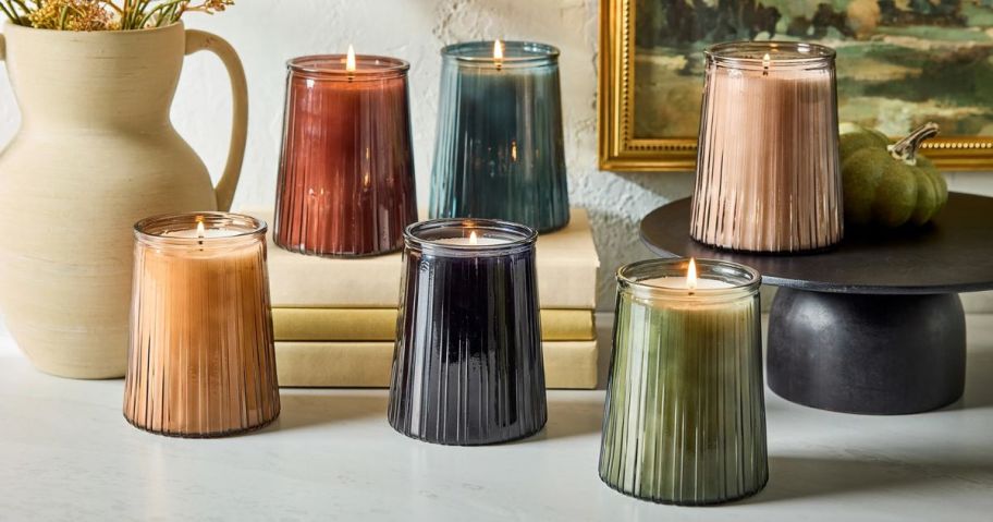 several glass ribbed candles in different colors