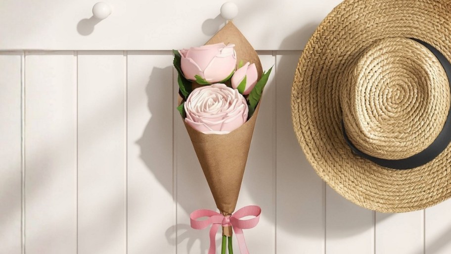 a paper flower bundle hanging next to a hat