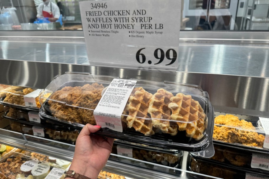 hand holding chicken and waffles meal in store