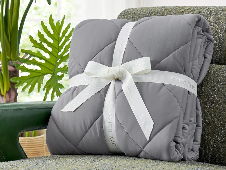 a grey cooling blanket tied with a bow sitting on a chair