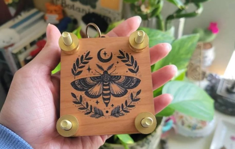 hand holding a mini flower press