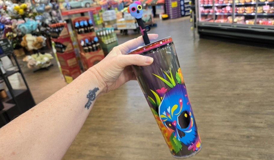 womans hand holding a candy skull tumbler
