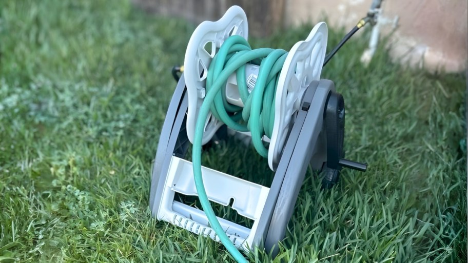 hose caddy in the grass next to a house