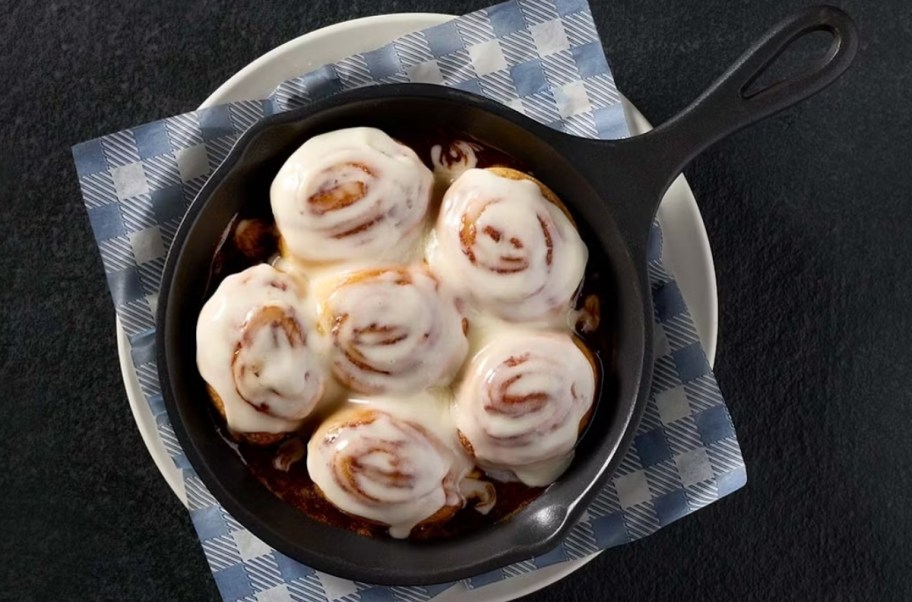 an iron skillet filled with fresh baked mini cinnamon rolls