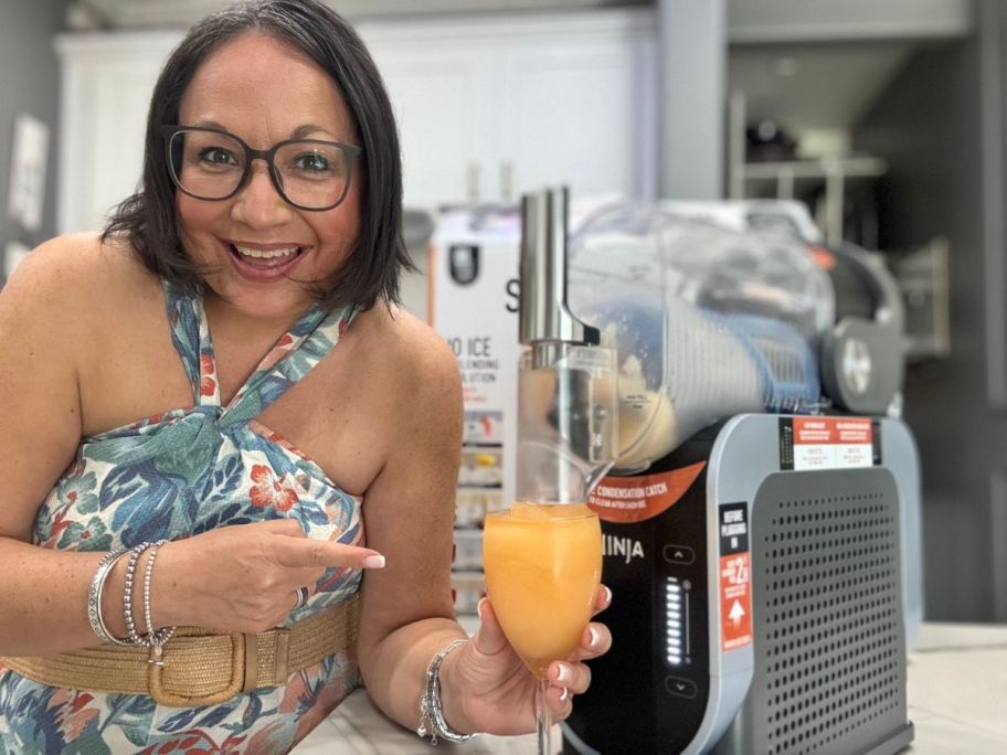 woman holding wine glass drink in front of ninja slushi 