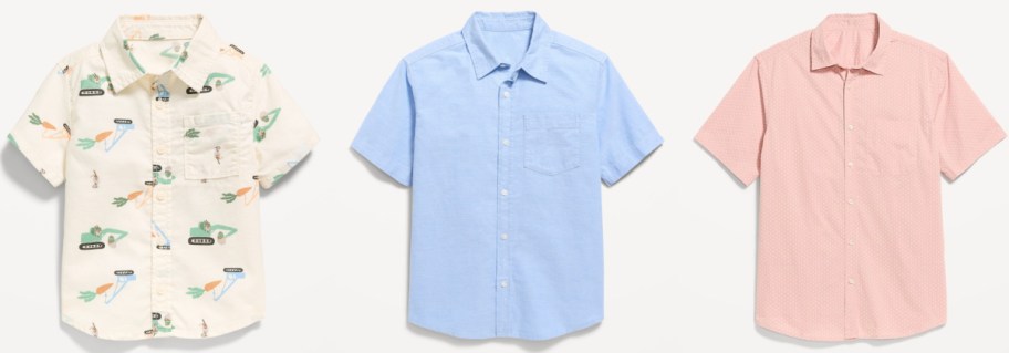 Three boys' short-sleeve shirts on a white background: a beige shirt with colorful dinosaur prints, a light blue shirt, and a pink shirt with subtle patterns.