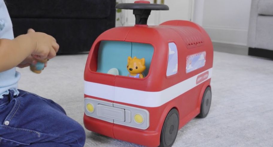 ride on toy displayed on a carpet closed up with child next to it 