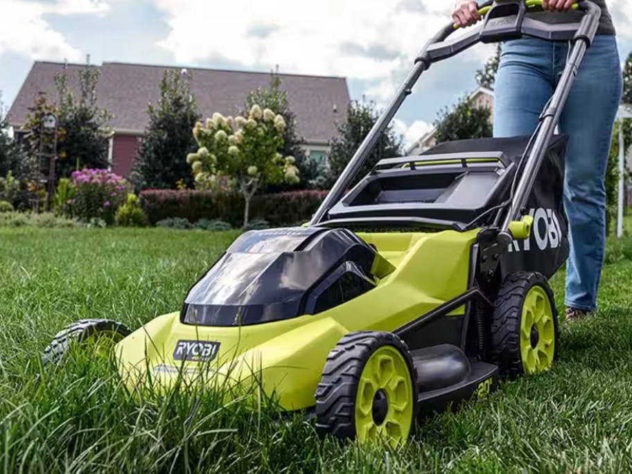 person using green ryobi mower