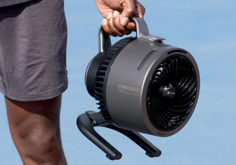 a man's hand holding a Shark flex breeze fan