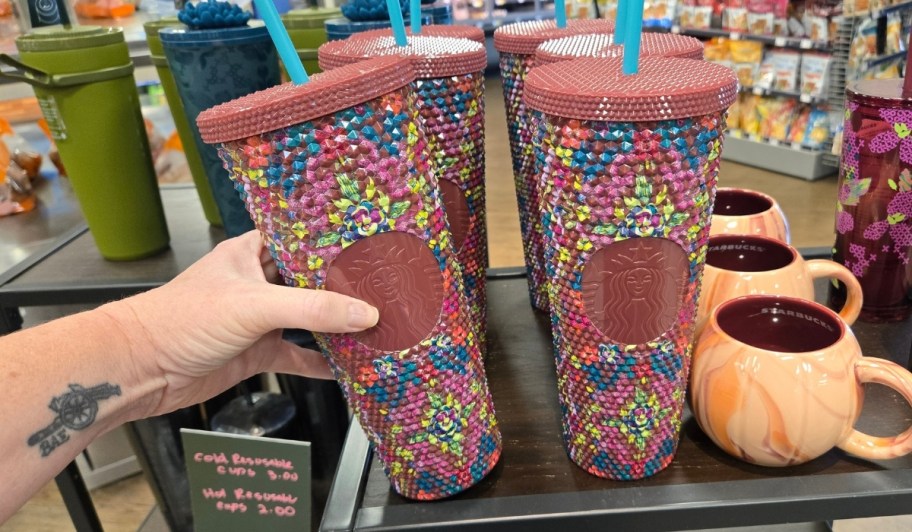 womans hand holding floral bling cup
