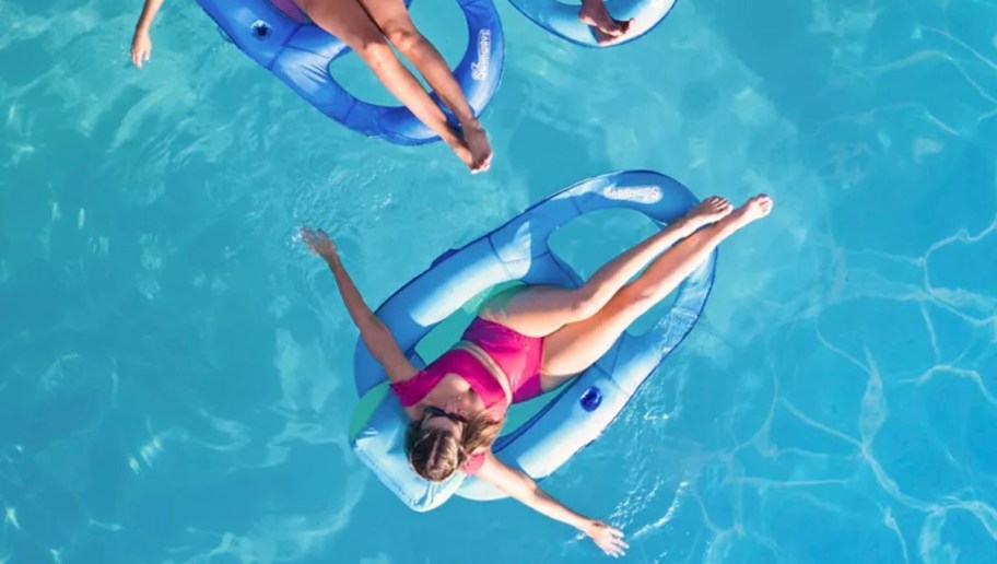 woman sitting on pool floats in pool water