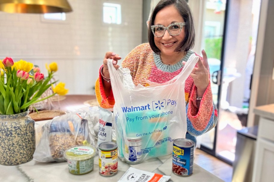woman standing in kitchen with walmart bags