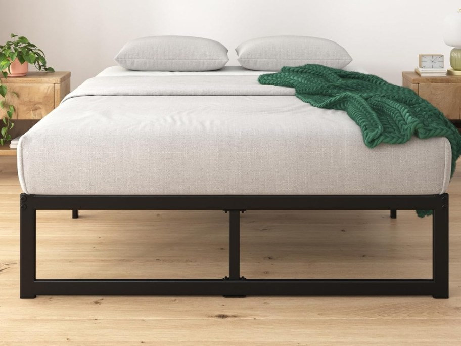 a metal bed frame with a mattress on it