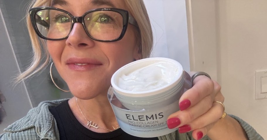Collin holding up a container of ELEMIS Pro-Collagen Marine Cream and smiling