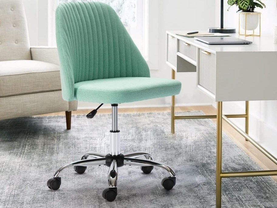 a green fabric rolling office chair in a home office