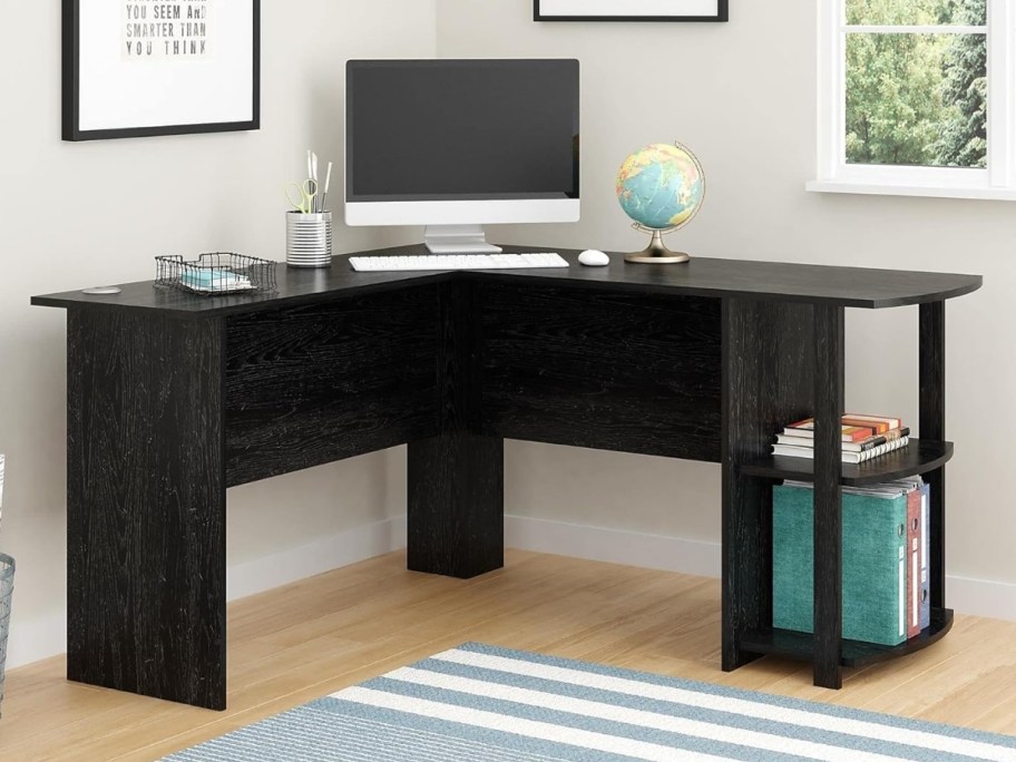 a black L shaped desk with shelves on one side
