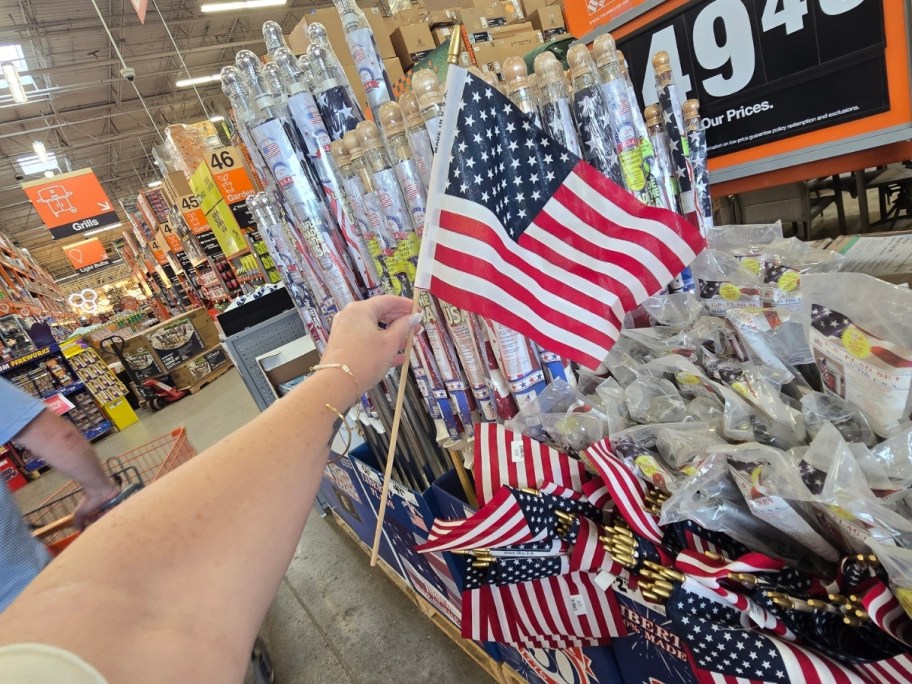 womans hand holding a small american flag