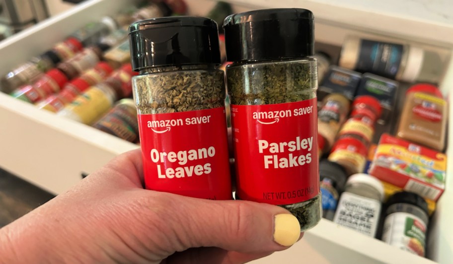 Person holding up bottles of oregano and parsley Amazon saver spices