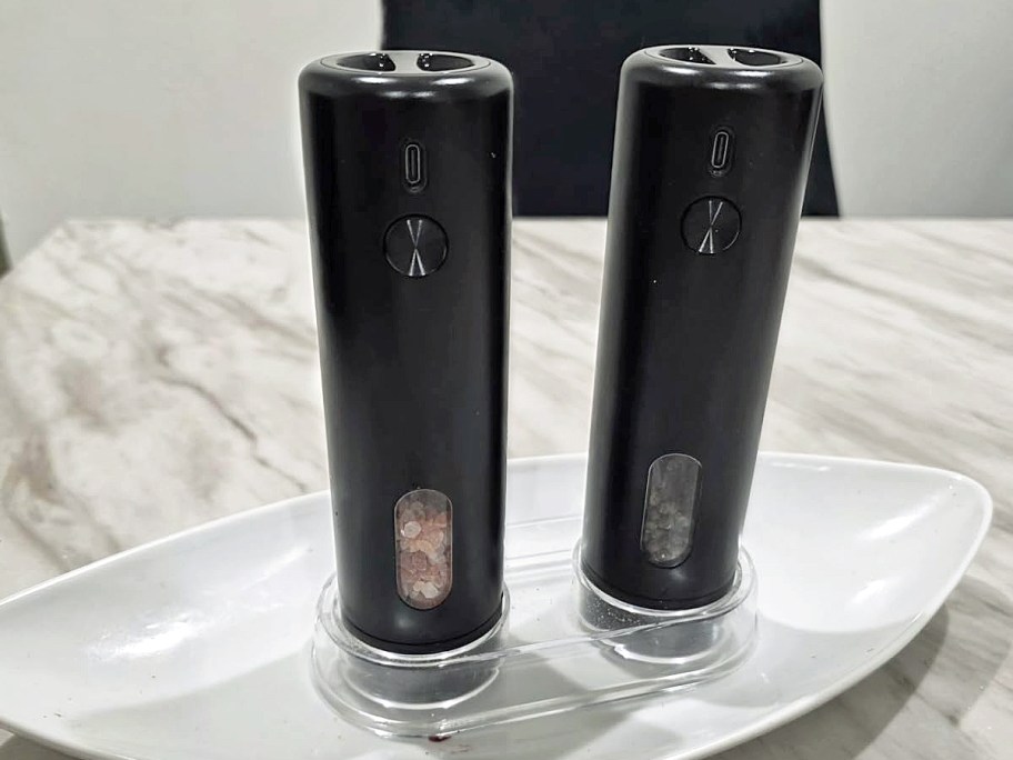 set of black electric salt & pepper grinders on plate on table