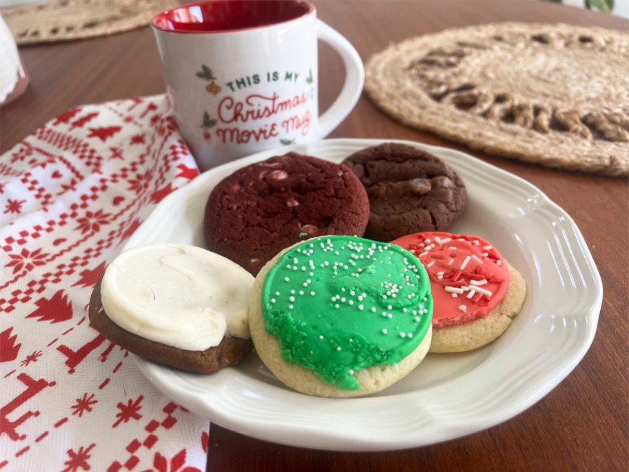 plate of christmas cookies on a table with a coffee mug