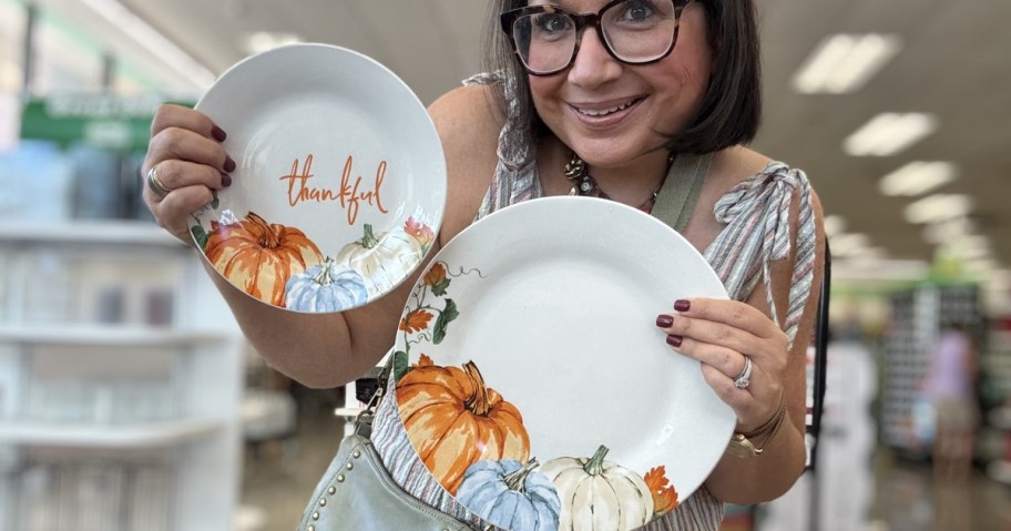 woman holding thankful and pumpkin fall dinner plates at dollar tree