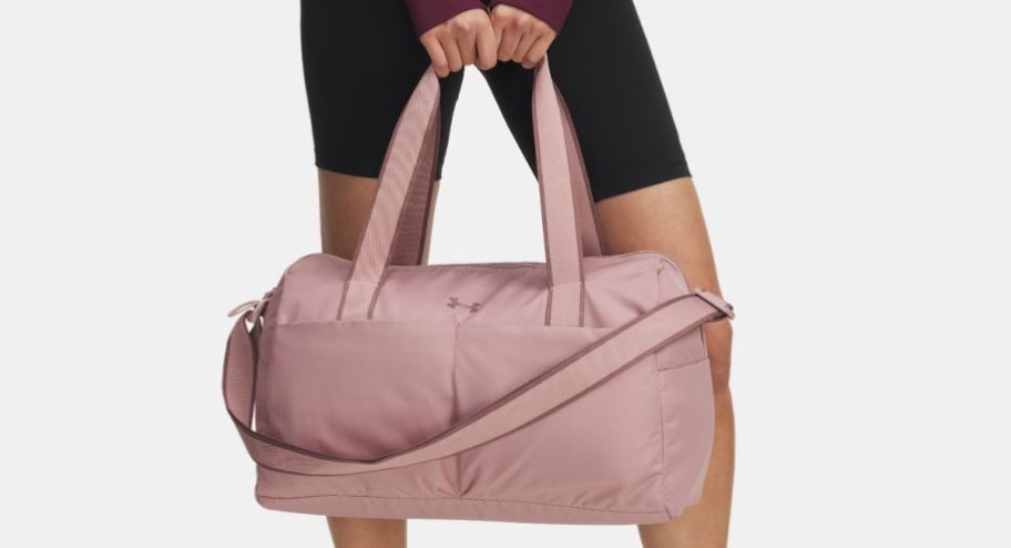 woman holding UA duffle bag in pink